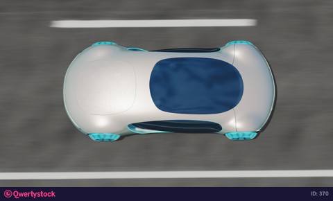 The electric car drives on the road against the backdrop of a deserted landscape.