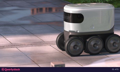 Automatic delivery robot driving down the morning street after rain